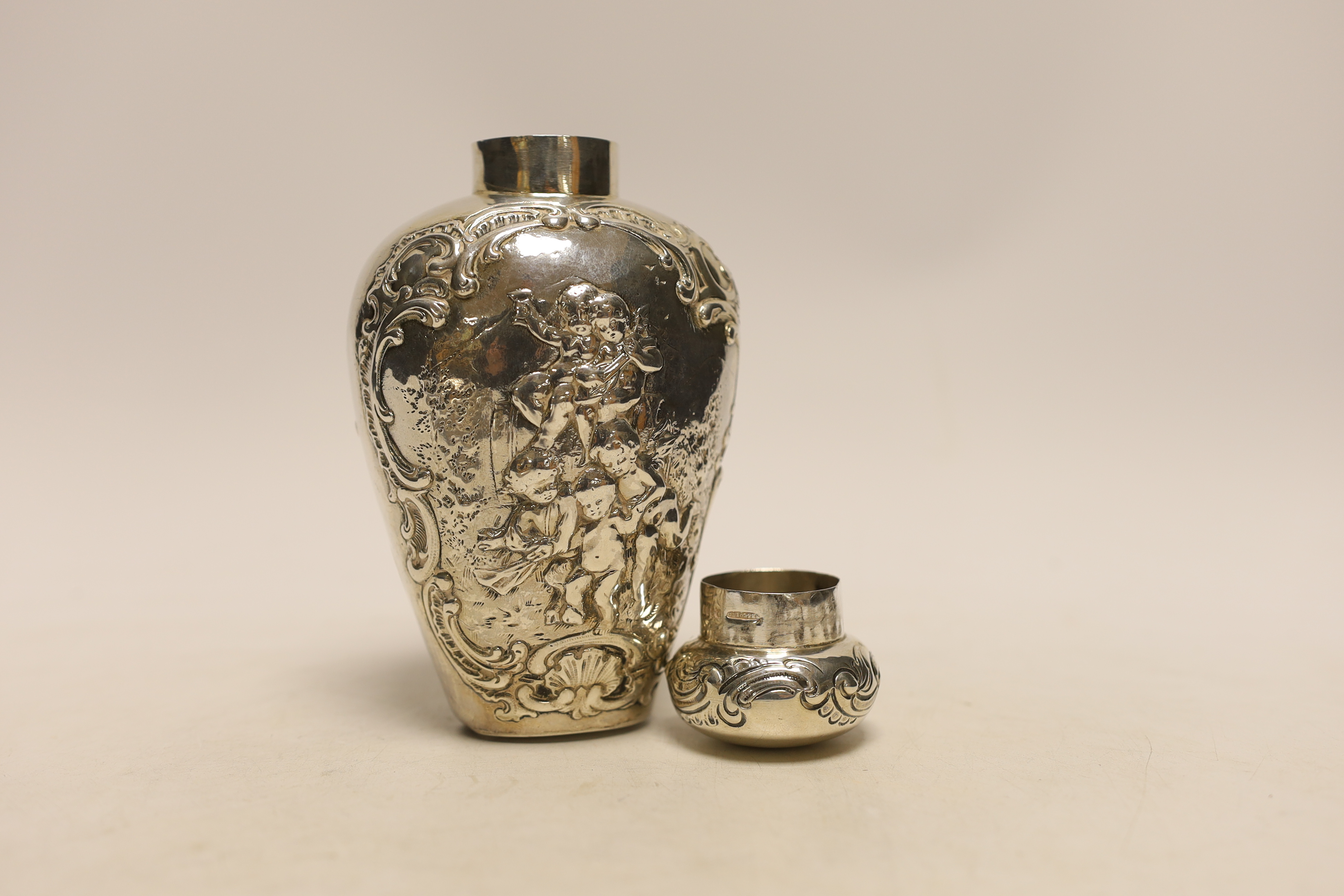 An Edwardian continental embossed silver tea caddy? and cover decorated with amorini, makers stamp to the base, import marks for London, 1902, height 15.8cm, 7.1oz.